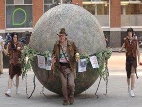 Indiana Jones courant devant une grosse boule en pierre