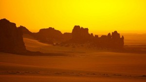 Désert de sable orangé sous ciel jaune avec traces de pas