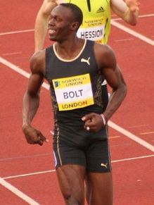 Usain Bolt en maillot noir souriant après une course