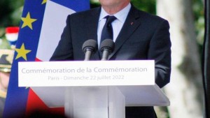 Représentant officiel français faisant un discours derrière un micro et devant les drapeaux français et européen