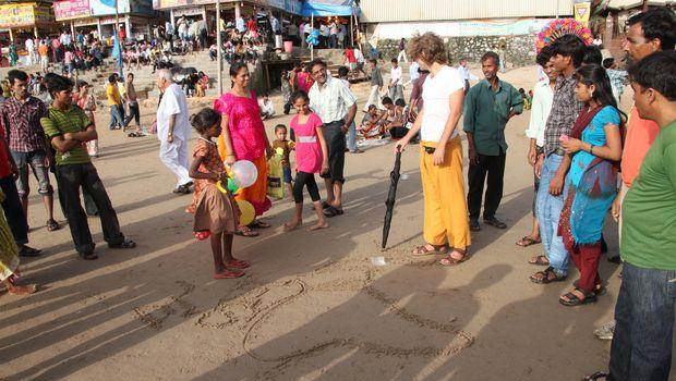 Nabolo explique d'où il vient à des passants indiens sur la plage de bombay