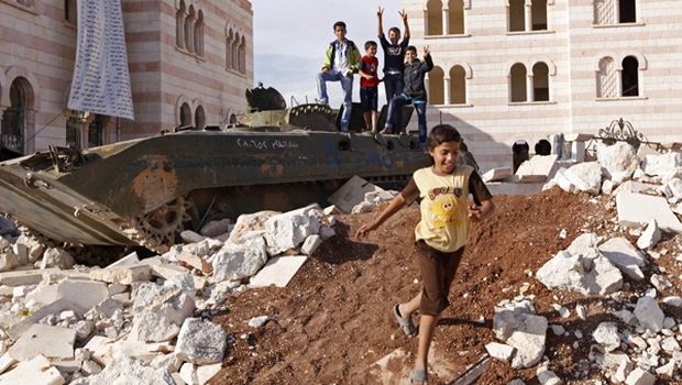 Enfants jouant dans les ruines de la guerre sur un vieux tank