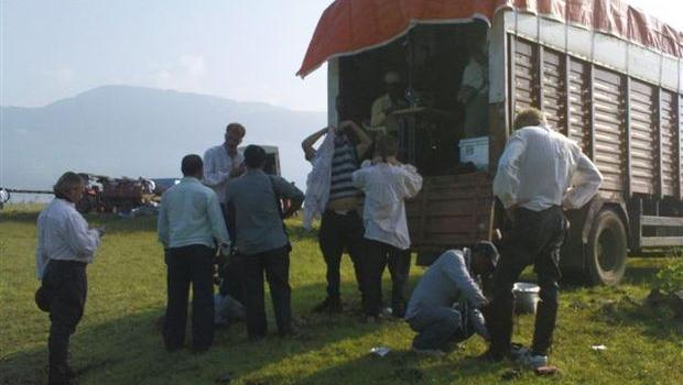 des figurants d'un film de bollywood se changent avant le tournage devant une caravane